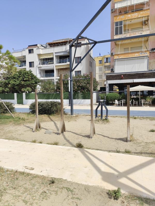 Nga ana e shëtitores, me një makineri kardio dhe lokalin prapa.