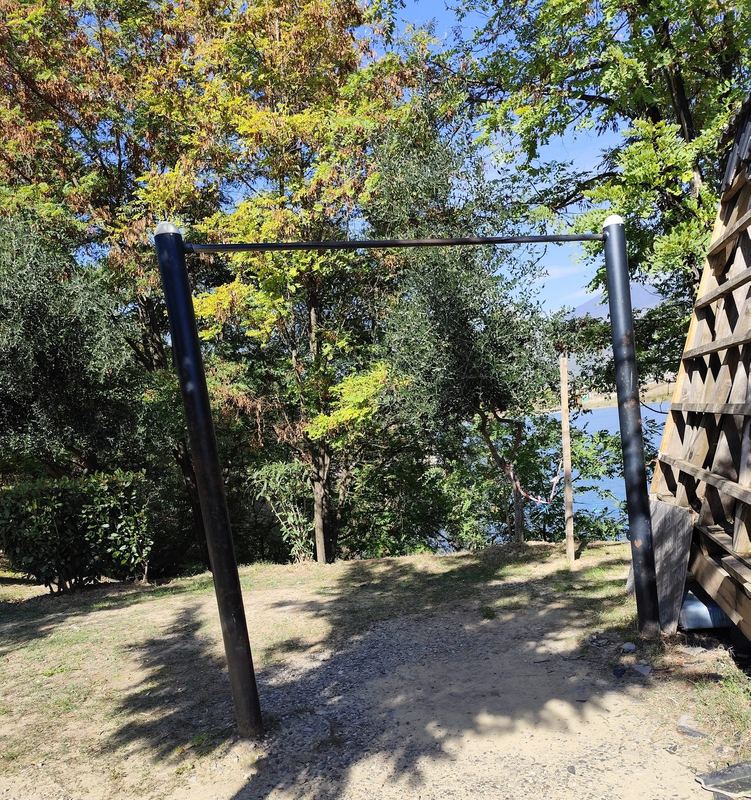 The pull-up bar beside the wooden hut, with the lake behind.