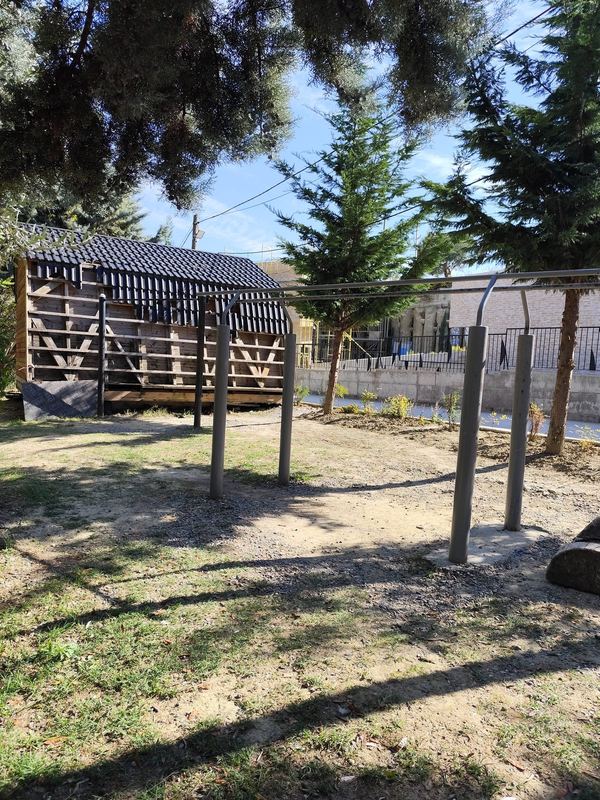 The parallel bars and the pull-up bar (left, in front of the hut).